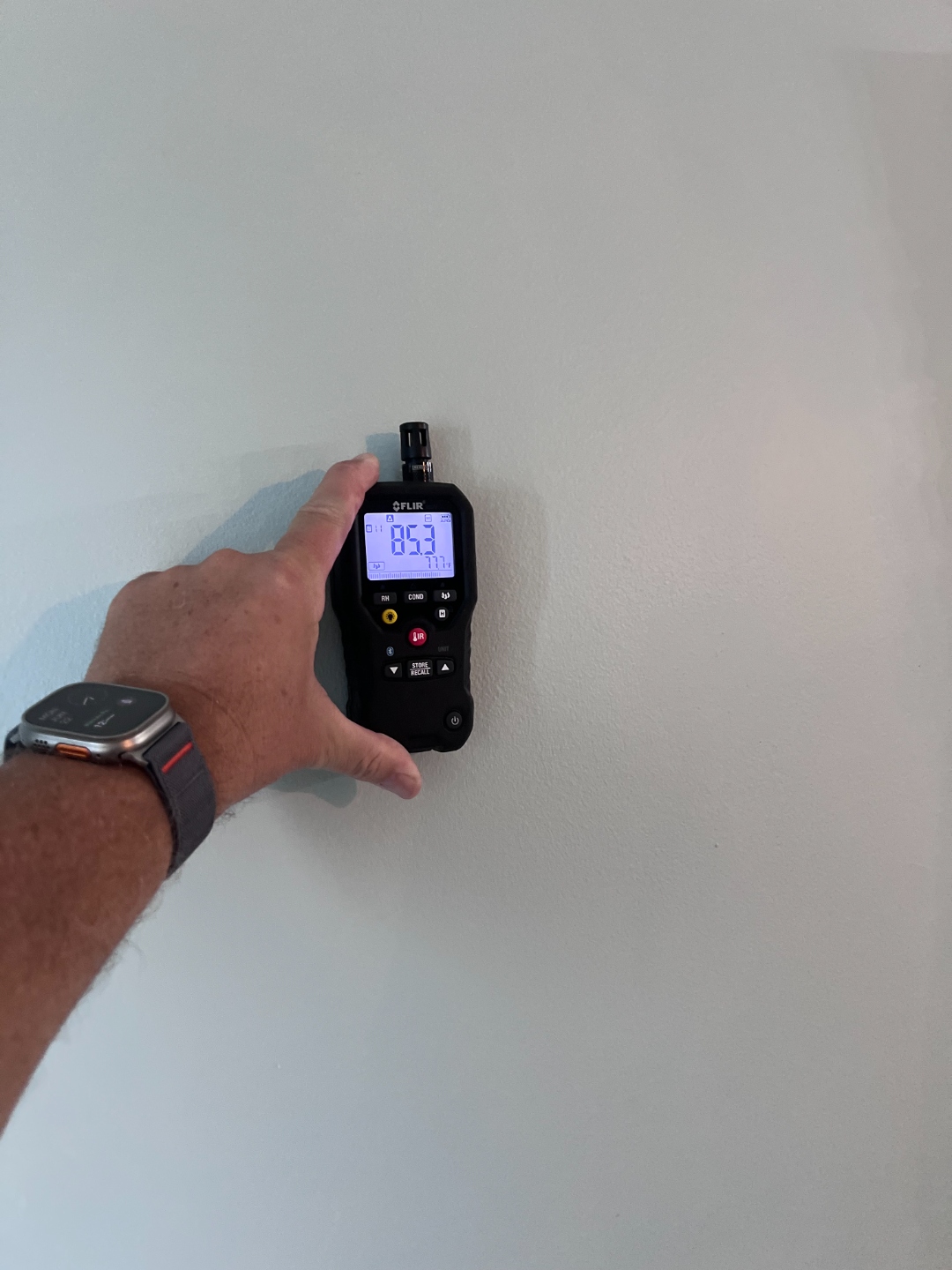 Moisture meter reading taken directly on an interior wall surface during a Home Enviro inspection