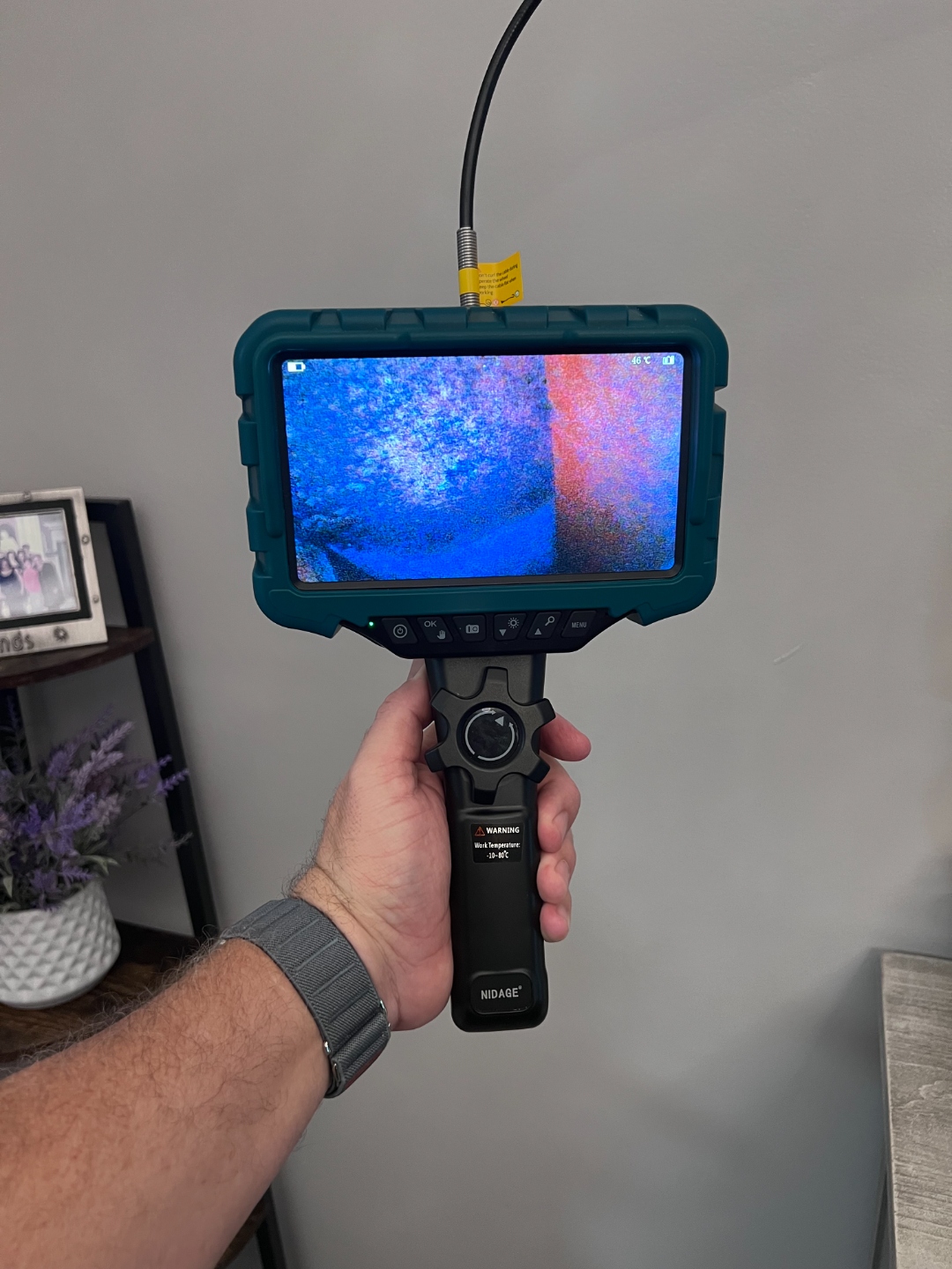 Borescope inspection camera displaying an internal cavity view during a building inspection
