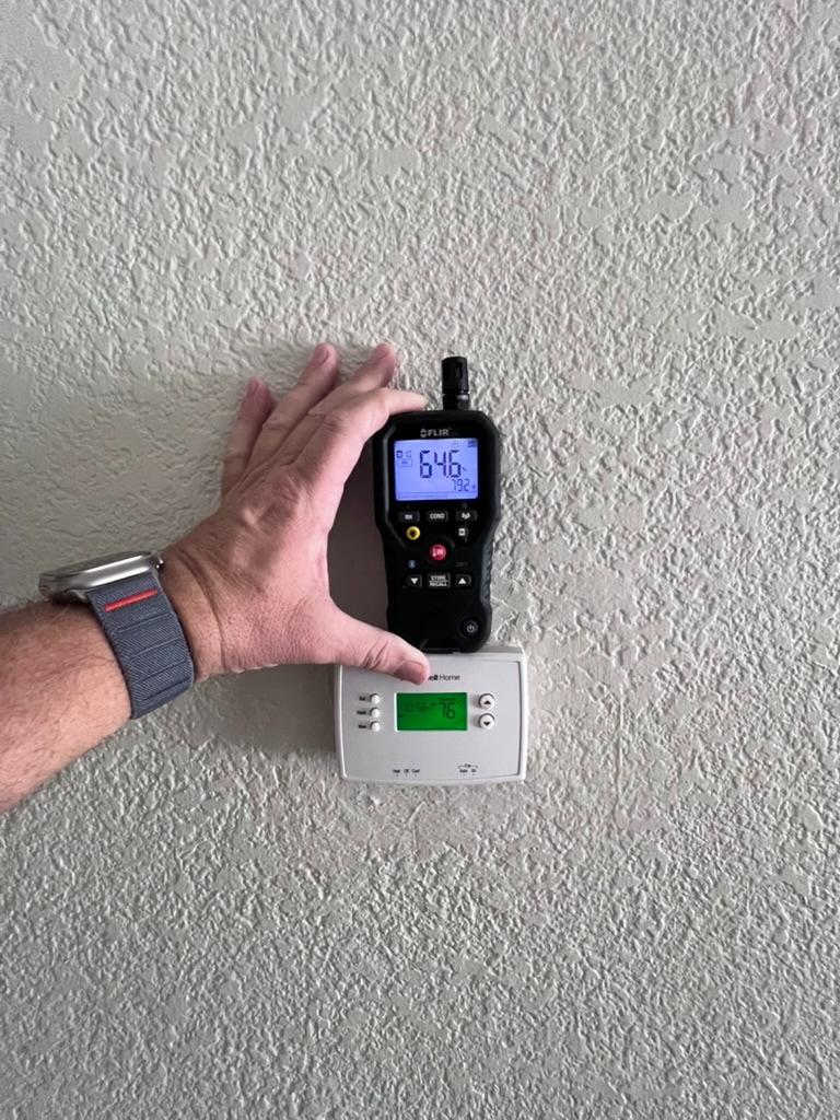 Moisture meter reading taken directly beside a wall thermostat